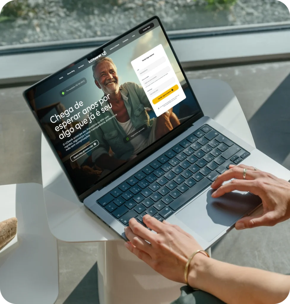 Pessoa usando laptop com site da LCbank exibindo mensagem sobre antecipação de precatórios e RPV.